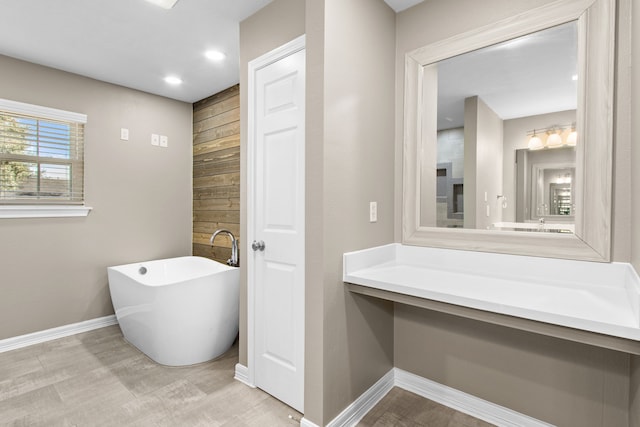 bathroom with a washtub and vanity