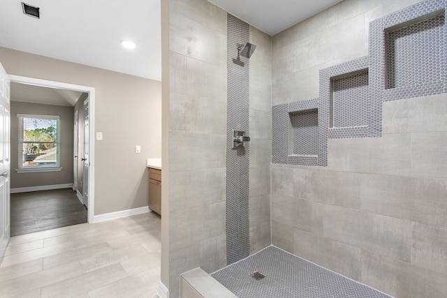 bathroom with vanity and a tile shower