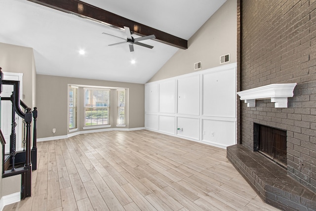 unfurnished living room featuring high vaulted ceiling, light hardwood / wood-style flooring, ceiling fan, a fireplace, and beamed ceiling