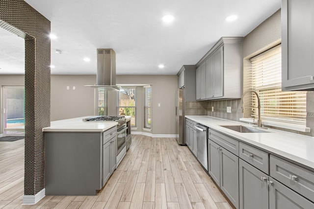 kitchen featuring gray cabinetry, sink, island exhaust hood, and stainless steel appliances