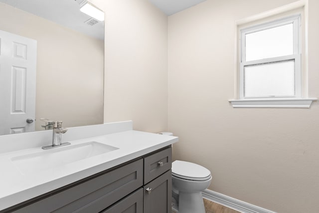 bathroom featuring vanity, wood-type flooring, and toilet