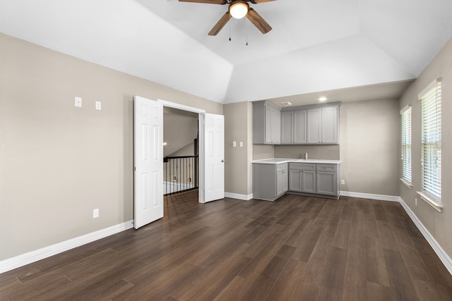 unfurnished living room with ceiling fan, dark hardwood / wood-style flooring, and vaulted ceiling