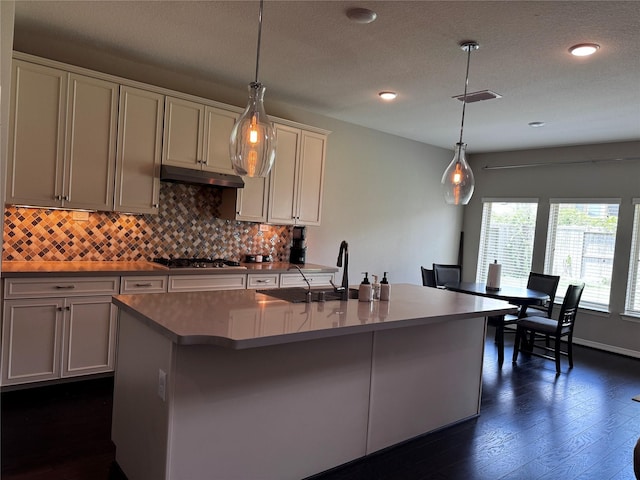 kitchen with a center island with sink, pendant lighting, and sink