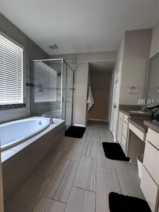 bathroom with vanity and separate shower and tub