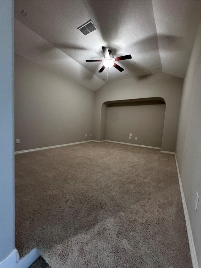 spare room featuring ceiling fan, lofted ceiling, a textured ceiling, and carpet floors