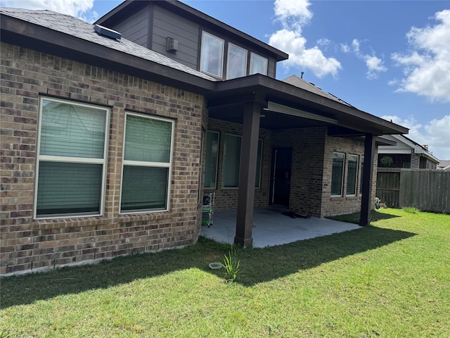 back of property featuring a patio area and a yard