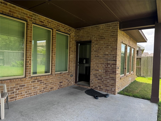 view of exterior entry with a patio area