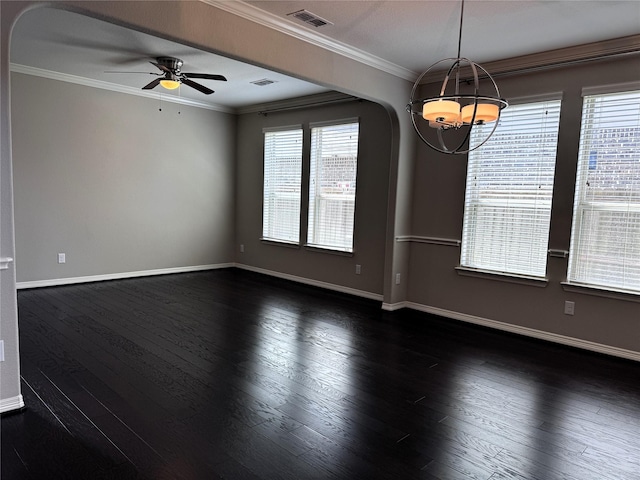 empty room with ceiling fan with notable chandelier, dark wood-type flooring, a wealth of natural light, and crown molding