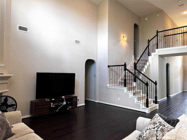 living room with dark hardwood / wood-style flooring and a high ceiling