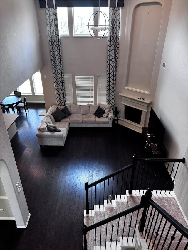 living room featuring wood-type flooring and an inviting chandelier