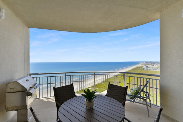 balcony with a water view and a view of the beach