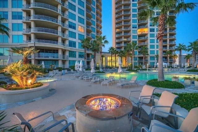 view of property's community with a patio area and an outdoor fire pit