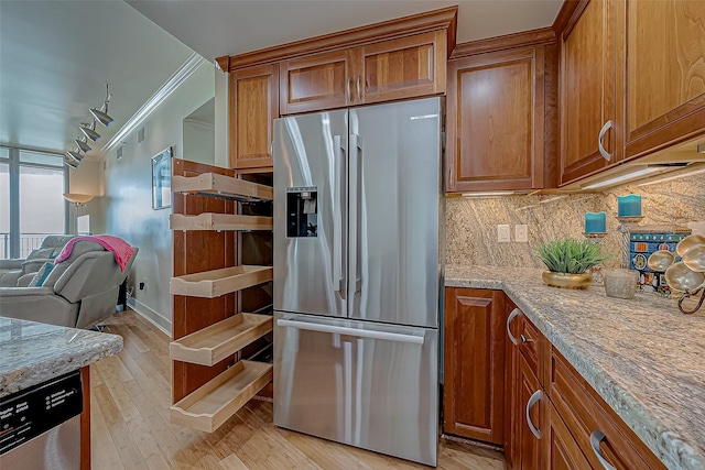 kitchen featuring stainless steel appliances, brown cabinetry, light wood-style floors, and tasteful backsplash