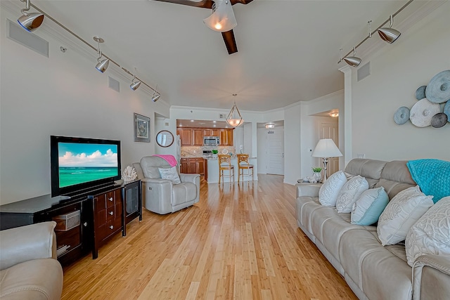 living room with visible vents, ceiling fan, and light wood-style flooring