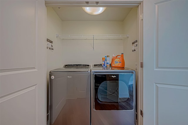 laundry room with washer and dryer, laundry area, and wood finished floors