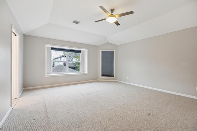 spare room with light carpet, vaulted ceiling, and ceiling fan