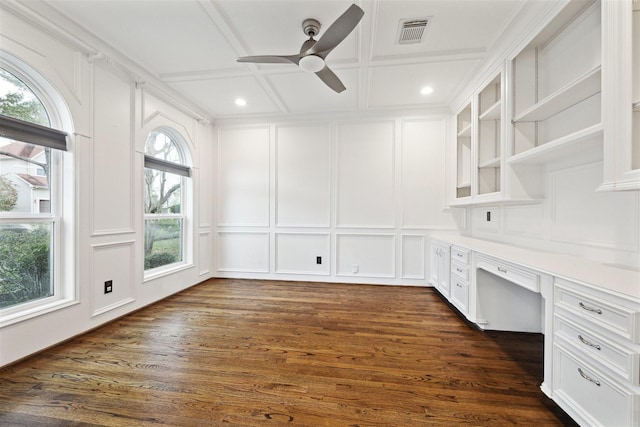 unfurnished office featuring ceiling fan, dark hardwood / wood-style flooring, built in desk, and coffered ceiling