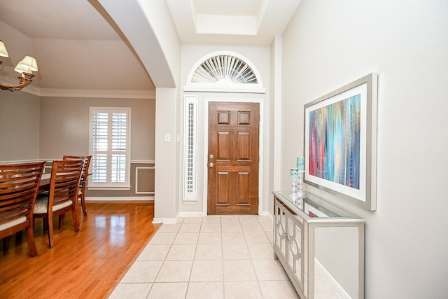 tiled entryway featuring crown molding