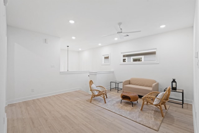 living area with ceiling fan and light hardwood / wood-style flooring