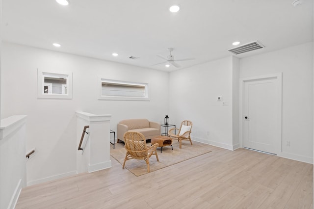 living area featuring ceiling fan and light hardwood / wood-style flooring