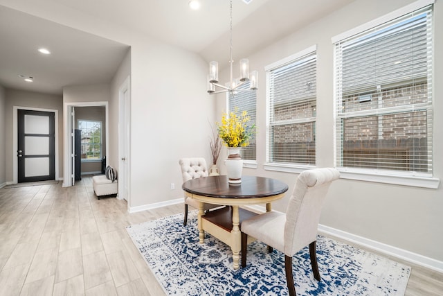 dining area with light hardwood / wood-style flooring and an inviting chandelier