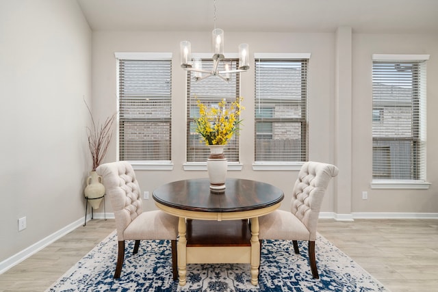 dining space with light hardwood / wood-style flooring and a notable chandelier