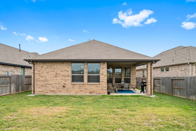 rear view of property featuring a lawn and a patio area