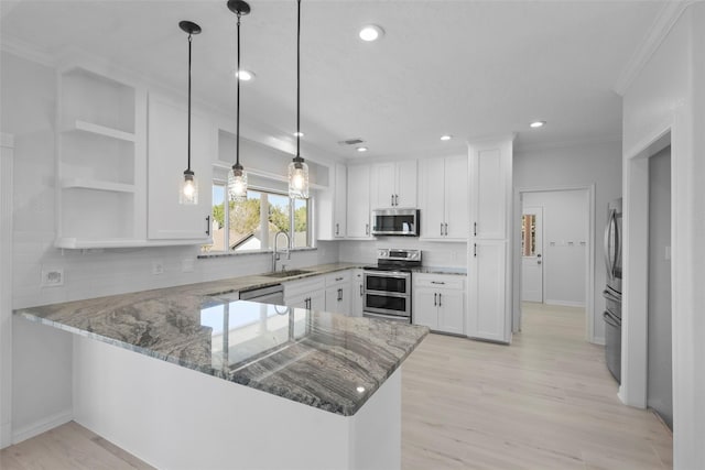 kitchen with kitchen peninsula, stainless steel appliances, white cabinetry, and sink