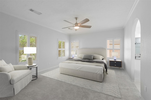 bedroom with ceiling fan, crown molding, and light colored carpet