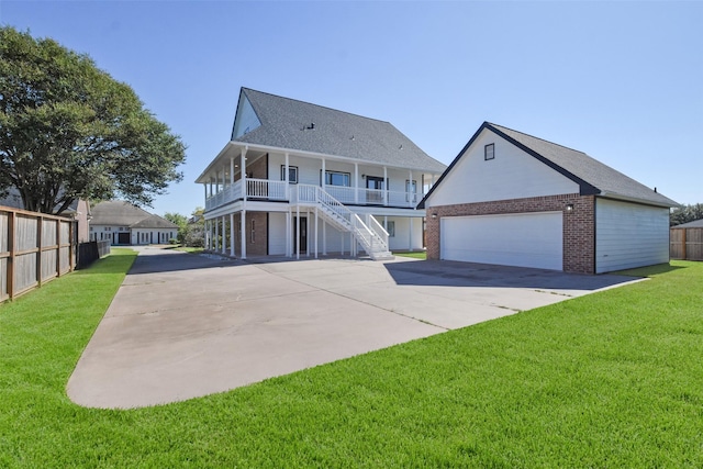 view of front of home with covered porch, a garage, and a front yard