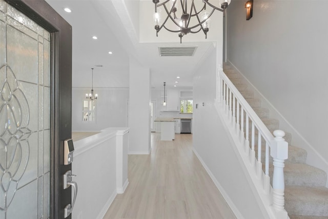 foyer entrance with a notable chandelier and light hardwood / wood-style floors