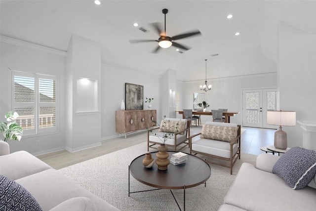 living room featuring french doors, ceiling fan with notable chandelier, light hardwood / wood-style floors, and crown molding