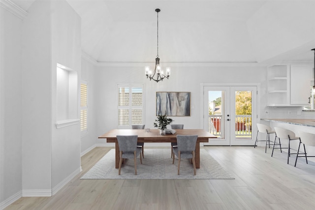 dining area with french doors, light hardwood / wood-style flooring, crown molding, and a notable chandelier