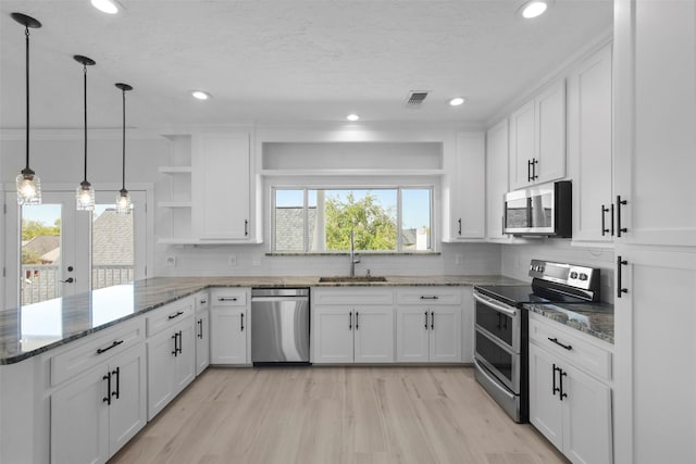 kitchen featuring backsplash, white cabinets, sink, kitchen peninsula, and stainless steel appliances