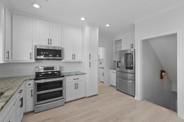 kitchen featuring backsplash, light stone countertops, white cabinets, and appliances with stainless steel finishes