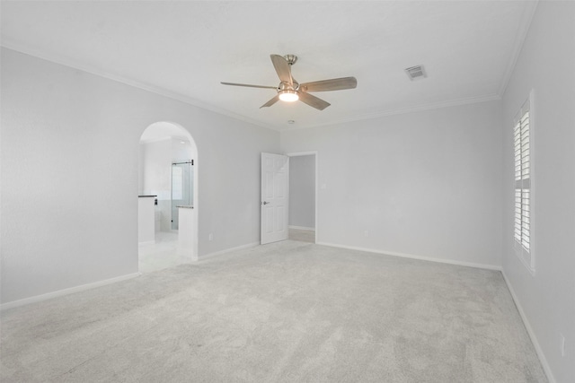 carpeted spare room with plenty of natural light, ceiling fan, and ornamental molding