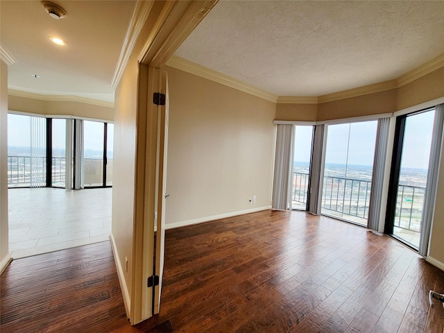 unfurnished room featuring dark hardwood / wood-style floors, ornamental molding, and a textured ceiling