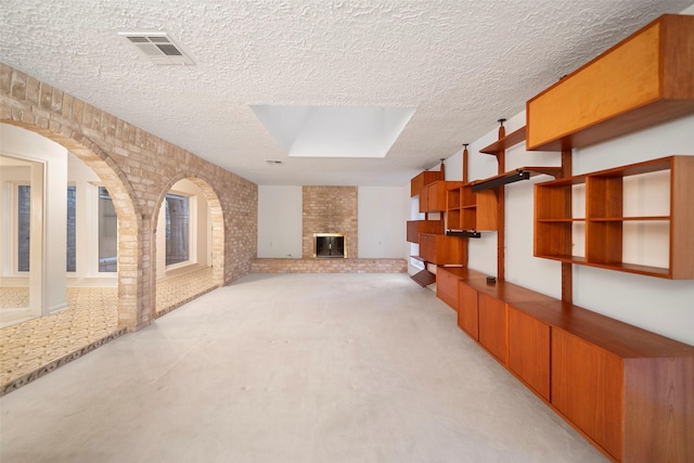 carpeted living room featuring a fireplace and a skylight