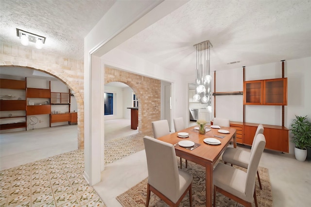 dining room featuring a textured ceiling and a notable chandelier