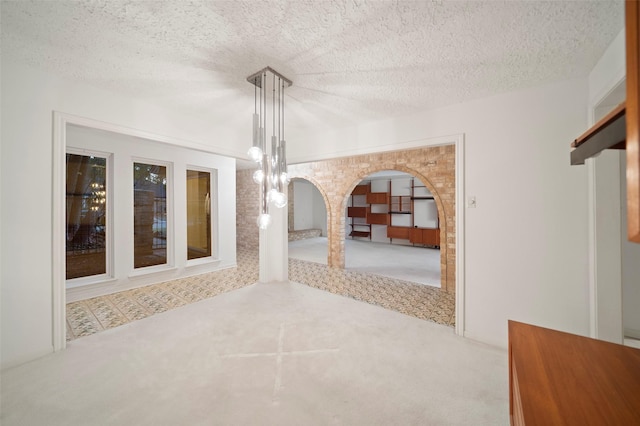 carpeted spare room featuring a textured ceiling