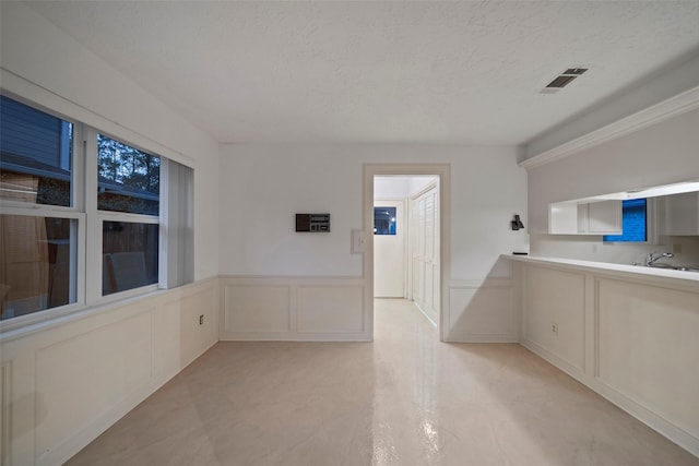 interior space with a textured ceiling and sink