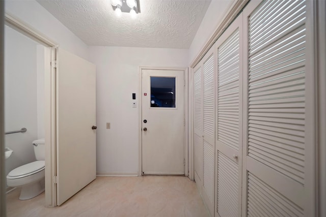 hall with a textured ceiling