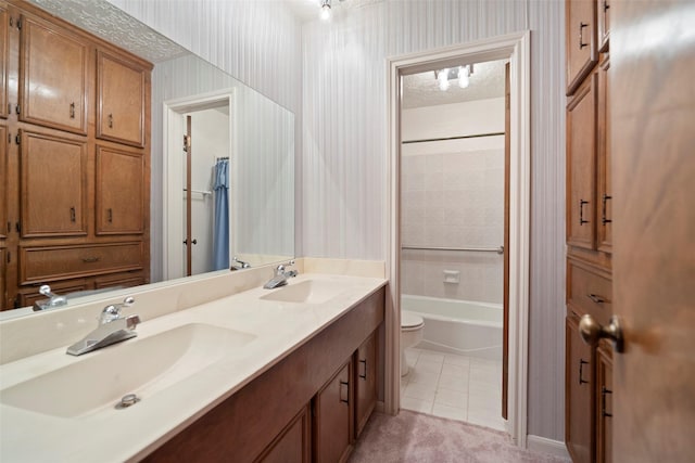 full bathroom featuring tile patterned floors, vanity, toilet, and tiled shower / bath combo