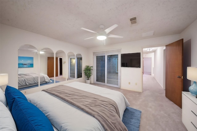 bedroom with a textured ceiling, ceiling fan, light carpet, and access to outside