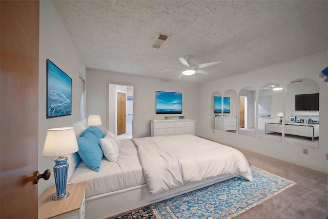 carpeted bedroom with a textured ceiling and ceiling fan