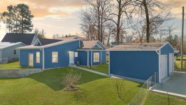 view of front of property featuring a yard, an outbuilding, and a garage