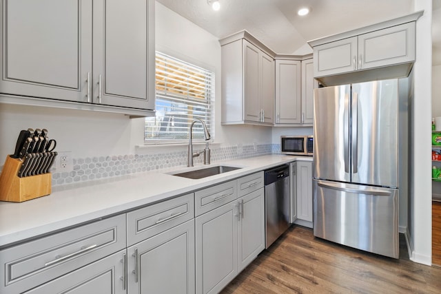 kitchen with sink, stainless steel appliances, hardwood / wood-style floors, and gray cabinets