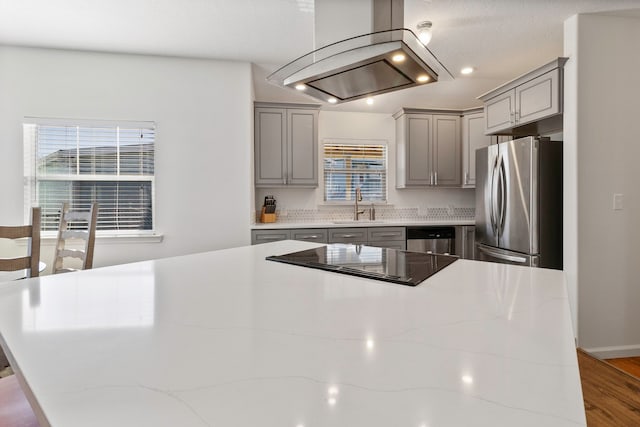 kitchen featuring light stone countertops, appliances with stainless steel finishes, gray cabinetry, and sink