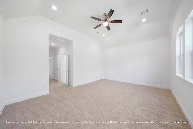 empty room with light carpet, vaulted ceiling, ceiling fan, and ornamental molding