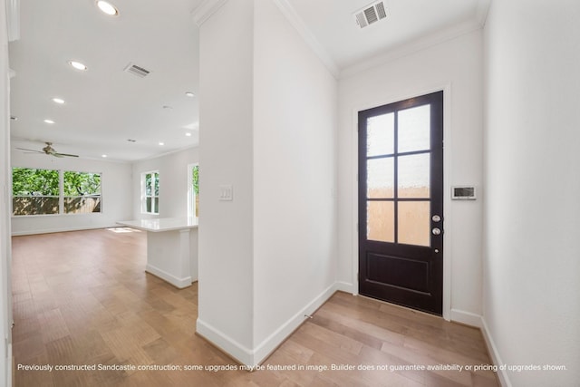 foyer entrance featuring ceiling fan, ornamental molding, and light wood-type flooring